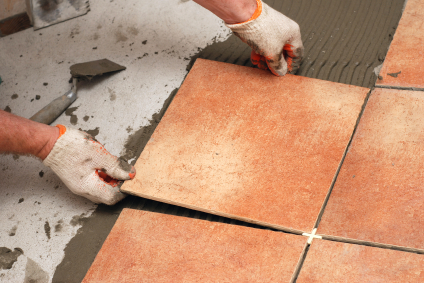 Installing tile flooring in a finished basement.